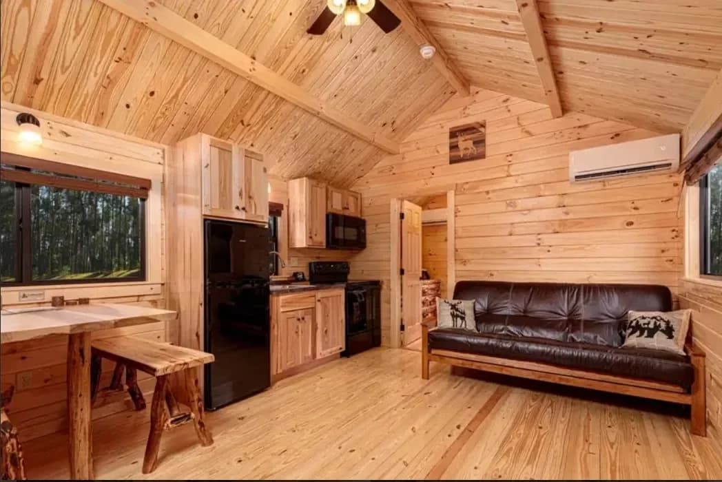 Pine cabin interior with a sitting area and kitchen
